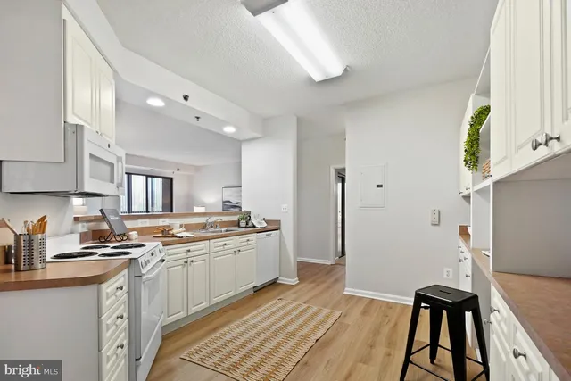 a kitchen with a sink appliances cabinets and a window