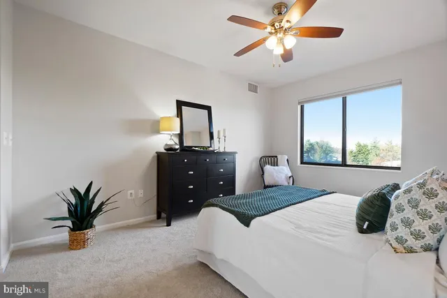 a bedroom with a large bed and a potted plant