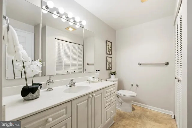 a bathroom with a double vanity sink toilet and mirror