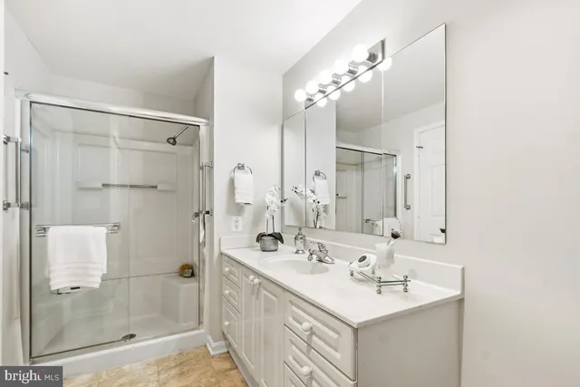 a bathroom with a sink shower and a mirror