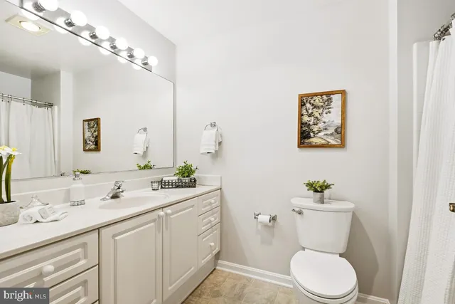 a bathroom with a granite countertop toilet sink and mirror