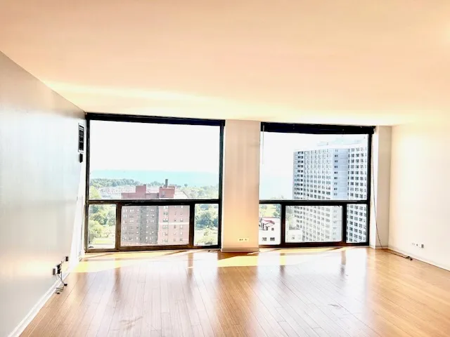 a view of a living room hardwood floor and a large window