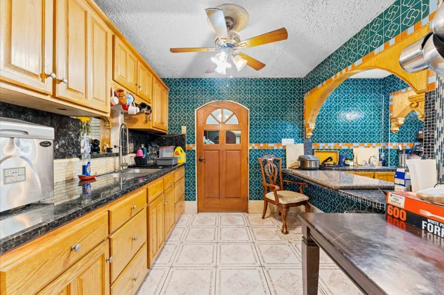 a kitchen with stainless steel appliances granite countertop a stove a sink and a dining table chair