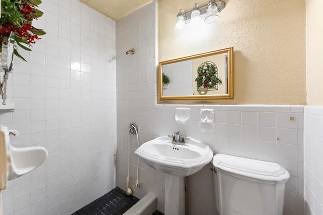 a bathroom with a sink and mirror with toilet