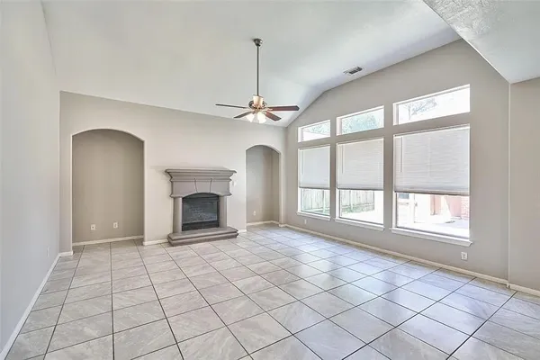 a view of an empty room with a fireplace and a window