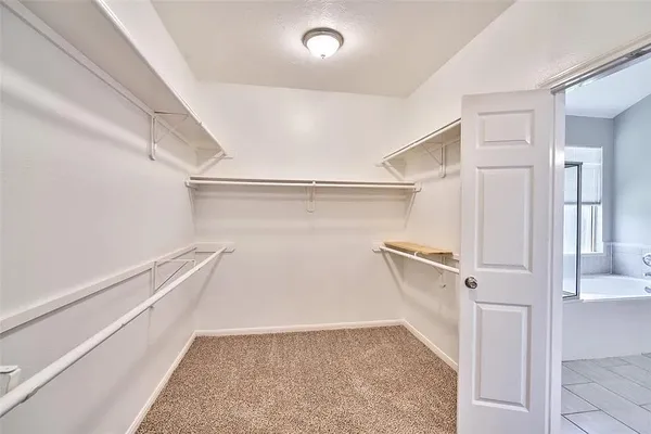 a view of walk in closet with empty racks