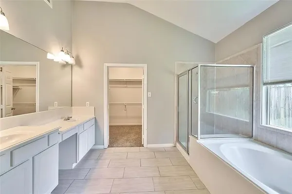 a spacious bathroom with a granite countertop sink a mirror a shower and a bathtub