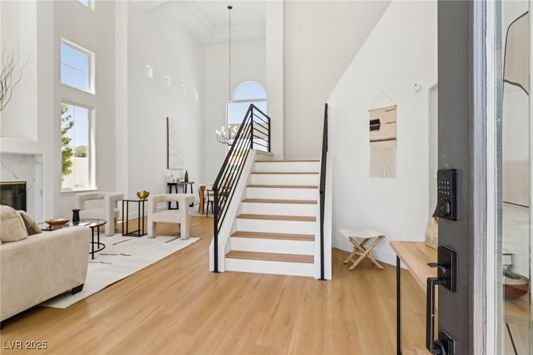 2469 Sun Reef Road Las Vegas, NV 89128 - Photo 4 of 93 Entrance foyer with a towering ceiling, light wood-style floors, stairway, and a fireplace