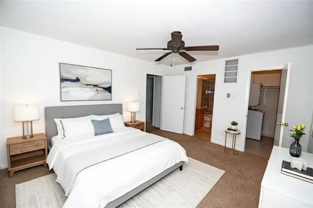 a bedroom with a bed and a mirror on the dresser