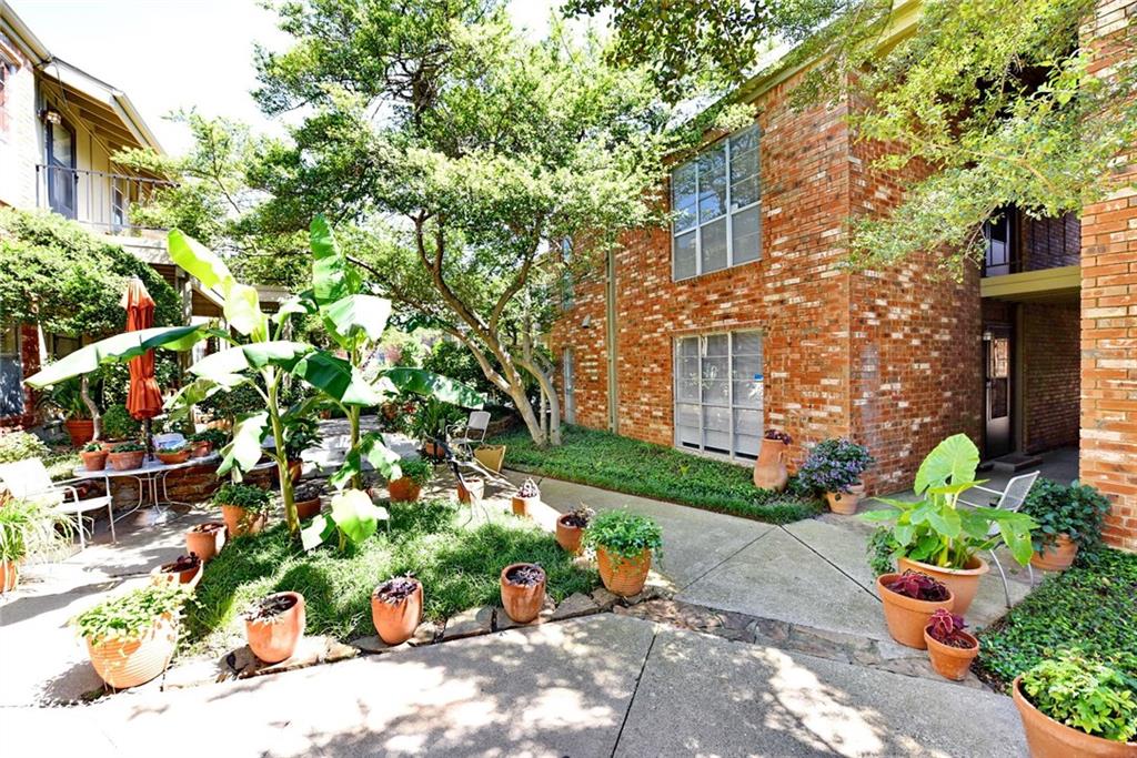 4317 Hartford Street, Unit 107 Dallas, TX 75219 - Photo 4 of 17 a bunch of flowers in front of brick building