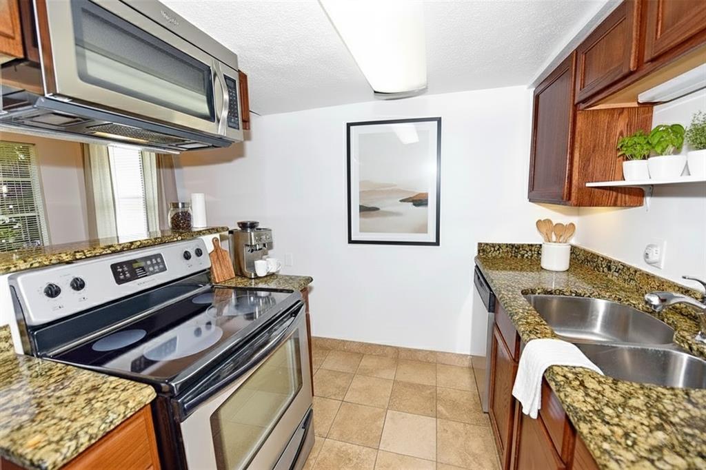 4317 Hartford Street, Unit 107 Dallas, TX 75219 - Photo 7 of 17 a kitchen with stainless steel appliances granite countertop a stove a sink and a microwave
