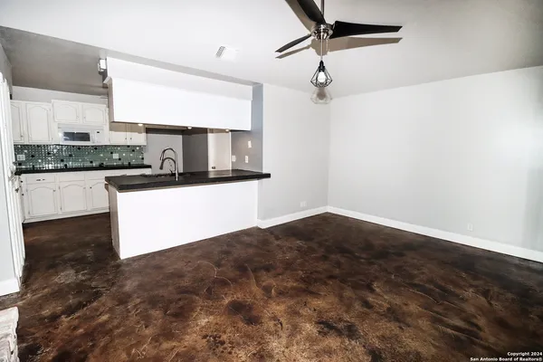 a view of empty room with a fireplace and fan