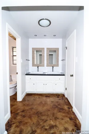 a view of a kitchen with refrigerator and white cabinets