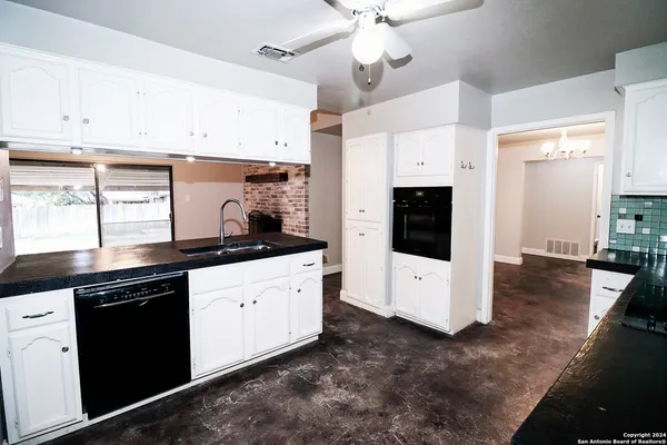 a kitchen with stainless steel appliances white cabinets and wooden floors