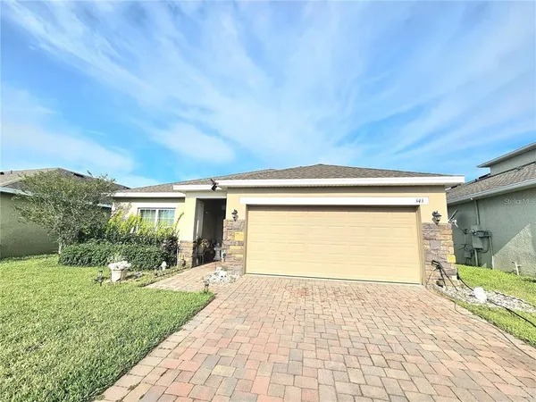 a front view of a house with a yard and potted plants