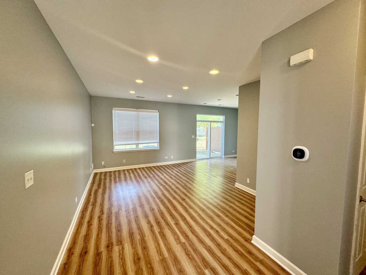 423 Acushnet Street, Unit 423 Elgin, IL 60124 - Photo 2 of 20 a view of an empty room with wooden floor and a window