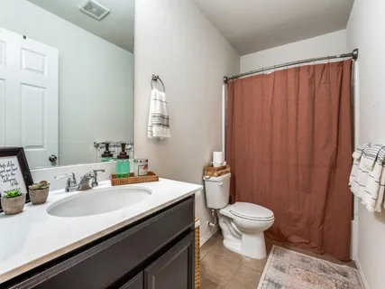 a bathroom with a granite countertop sink a mirror and a shower