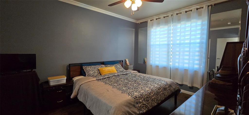 1100 West Trinity Mills Road, Unit 2045 Carrollton, TX 75006 - Photo 4 of 20 Bedroom with ornamental molding and ceiling fan