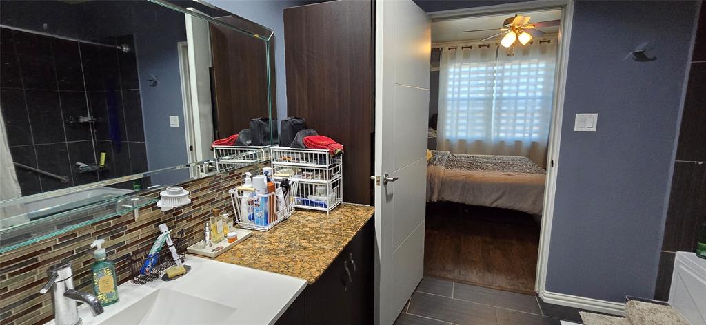 1100 West Trinity Mills Road, Unit 2045 Carrollton, TX 75006 - Photo 6 of 20 Full bathroom with ceiling fan, vanity, and connected bathroom