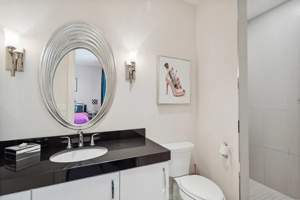 a bathroom with a toilet a sink and a mirror