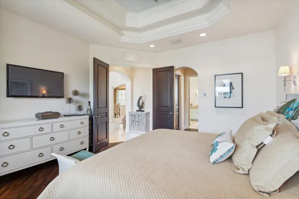 a bedroom with a bed and dresser with mirror