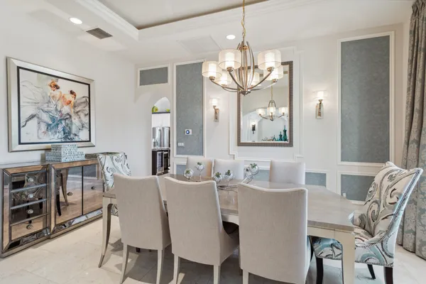 a view of a dining room with furniture a chandelier and wooden floor