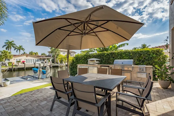 a view of a patio with a table and chairs under an umbrella