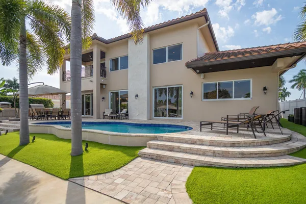 a view of a house with swimming pool and sitting area