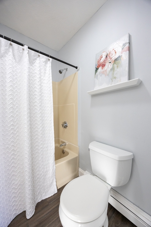 35 Hazel Street, Unit B Attleboro, MA 02703 - Photo 26 of 33 a white toilet sitting next to a bathroom sink and a shower curtain