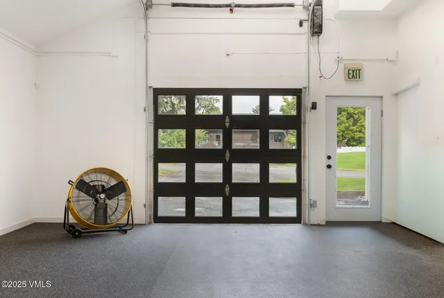 a view of a white house with a big yard and large tree