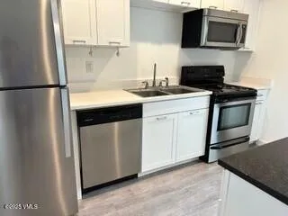 a bathroom with a granite countertop bathtub shower sink vanity and toilet