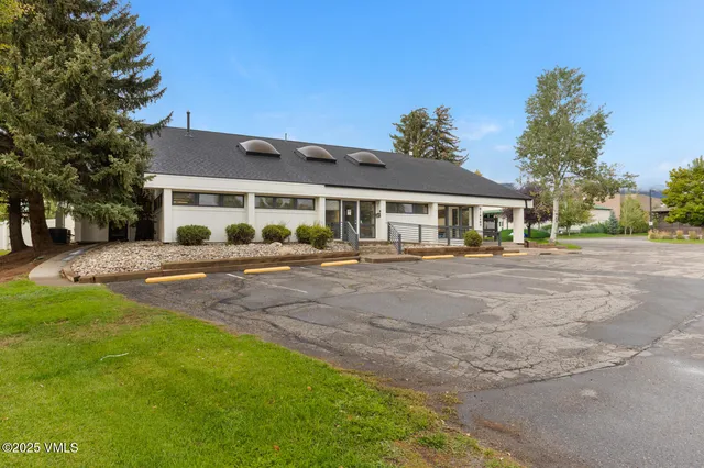 a front view of a house with a garden and trees