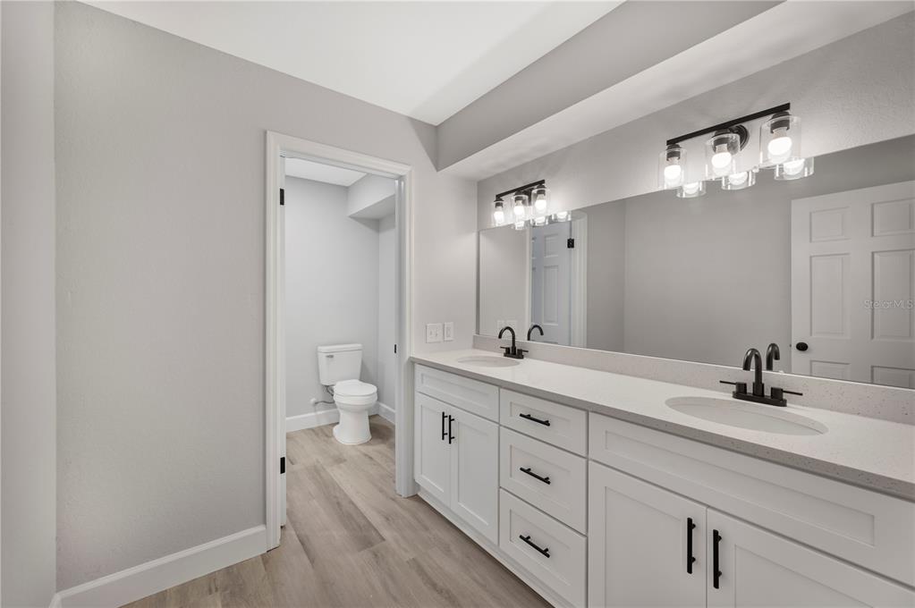 241 Greenfield Road Winter Haven, FL 33884 - Photo 19 of 43 a spacious bathroom with a double vanity sink a large mirror a toilet and vanity