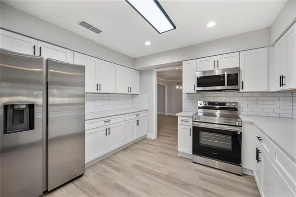 a kitchen with stainless steel appliances granite countertop a stove microwave and a refrigerator