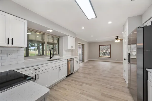 a large kitchen with a lot of counter space and wooden floor