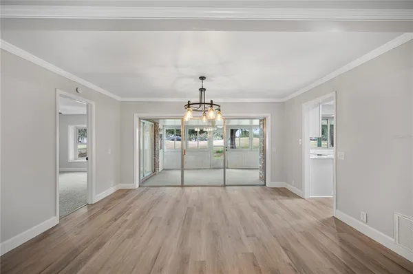 a room with a chandelier and wooden floor