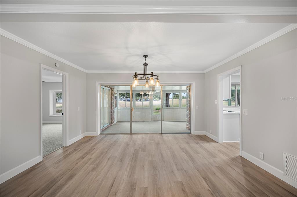 241 Greenfield Road Winter Haven, FL 33884 - Photo 8 of 43 a room with a chandelier and wooden floor