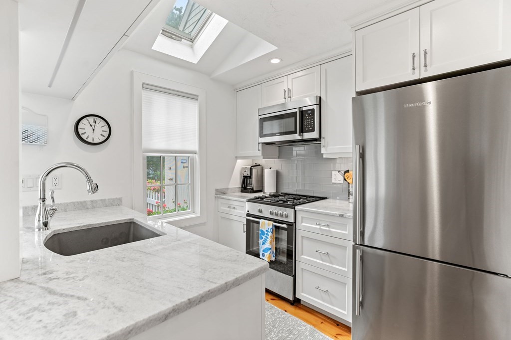 3 Folgers Way, Unit 3 Mashpee, MA 02649 - Photo 14 of 21 a kitchen with stainless steel appliances granite countertop a refrigerator a stove a sink and a refrigerator with wooden floor