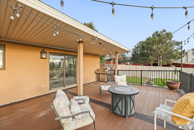 2342 Charros Road Sandy, UT 84092 - Photo 66 of 94 Spacious outdoor deck featuring composite decking, a built-in outdoor lighting system, a sliding glass door, and a black metal railing