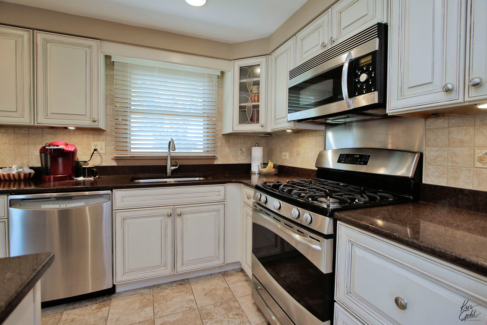 720 Stuart Street Grayslake, IL 60030 - Photo 6 of 19 a kitchen with stainless steel appliances granite countertop white cabinets and window