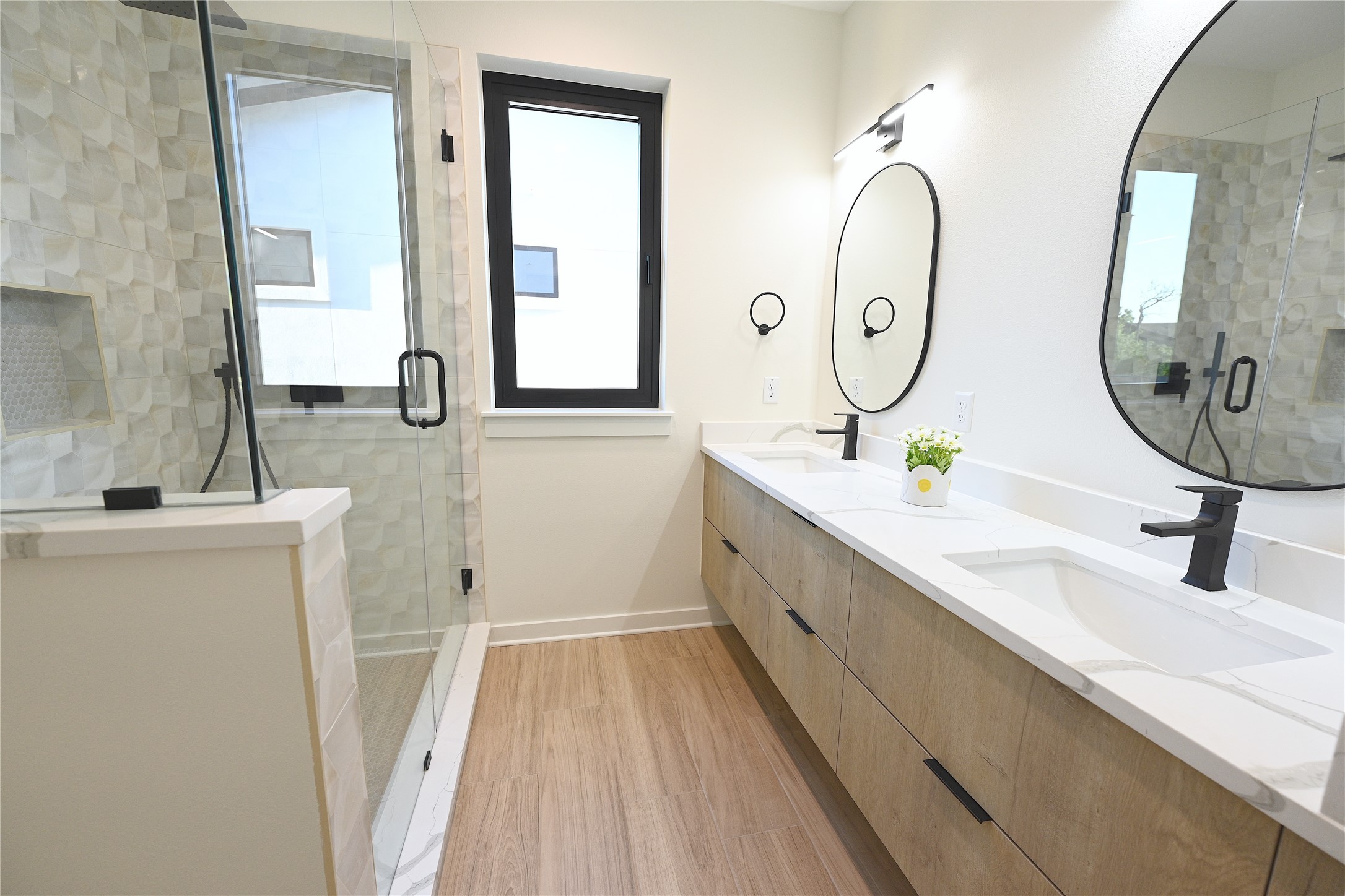 4410 Glomar Avenue, Unit 2 Austin, TX 78721 - Photo 18 of 24 Master Bathroom featuring a double vanity with white countertops, modern black faucets, and two unique mirrors