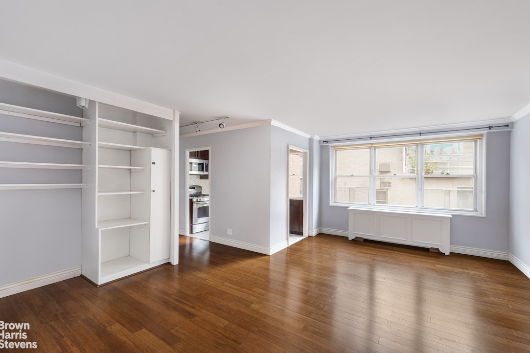 251 East 32nd Street, Unit 4J Manhattan, NY 10016 - Photo 13 of 15 a view of an empty room with a window and wooden floor
