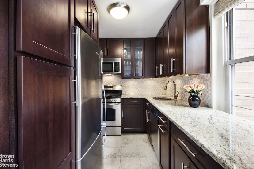 251 East 32nd Street, Unit 4J Manhattan, NY 10016 - Photo 3 of 15 a kitchen with stainless steel appliances granite countertop a refrigerator and a sink
