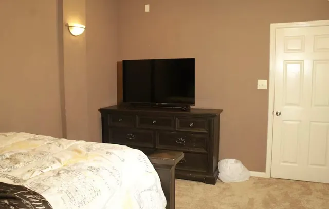 a bedroom with a bed and a flat screen tv