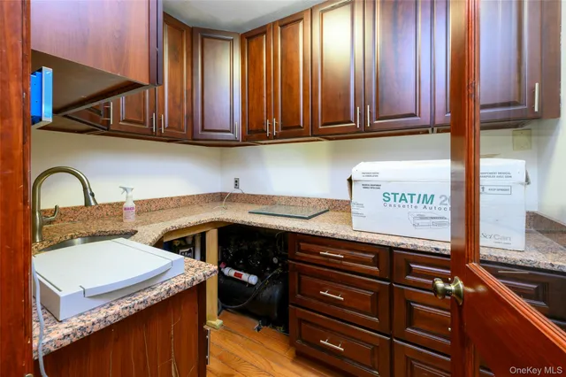 a kitchen with granite countertop wooden cabinets and a sink