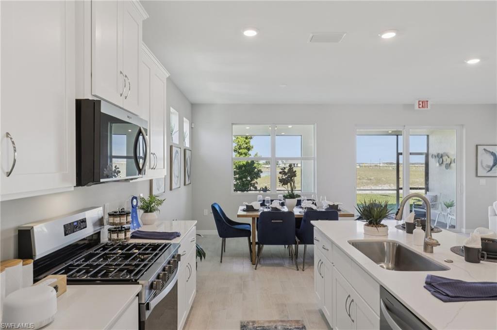 17899 Shade Tree Loop Punta Gorda, FL 33982 - Photo 11 of 47 a kitchen with stainless steel appliances granite countertop a sink stove and cabinets