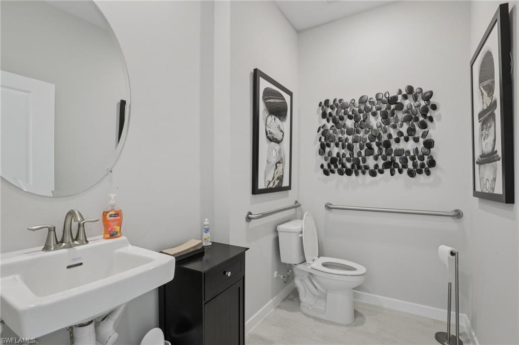 17899 Shade Tree Loop Punta Gorda, FL 33982 - Photo 17 of 47 a bathroom with a toilet sink and mirror