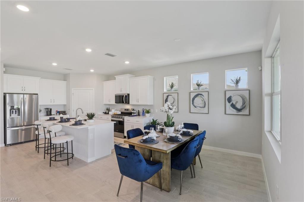 17899 Shade Tree Loop Punta Gorda, FL 33982 - Photo 6 of 47 a view of a dining room and livingroom with furniture wooden floor a rug and a clock