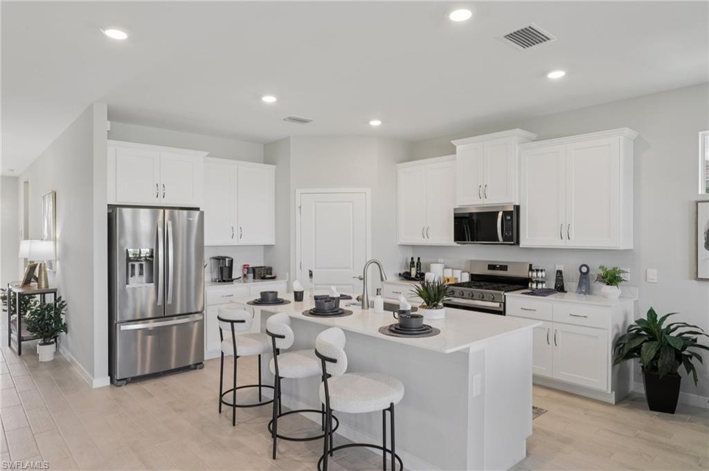 17899 Shade Tree Loop Punta Gorda, FL 33982 - Photo 10 of 47 a kitchen with stainless steel appliances a microwave sink refrigerator and cabinets