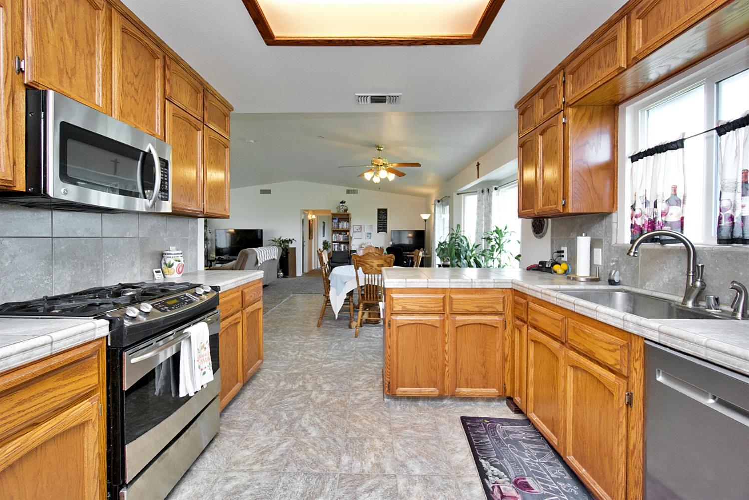 16254 Road 37 Madera, CA 93636 - Photo 10 of 36 a kitchen with stainless steel appliances granite countertop a stove a sink dishwasher and a microwave oven with large cabinets